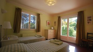 A room with two beds, a radiator, a window with curtains, a chair, and a lamp. - SUPERB SECLUDED VILLA WITH STUNNING VIEWS AND HEATED SWIMMING POOL 
 (Saint-Antonin-Du-Var)