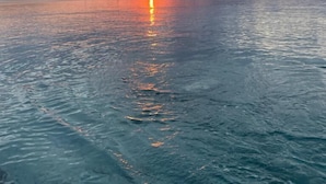 Un cuerpo de agua tranquilo reflejando el atardecer.