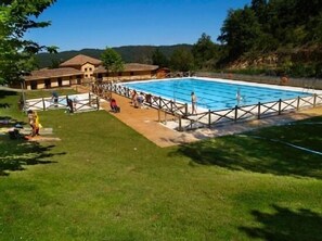 A swimming pool with a wooden deck and a fenced area, surrounded by grass and trees. - OFFER - Rural house (full rental) Gaztelubidea for 6 people (Bernedo)