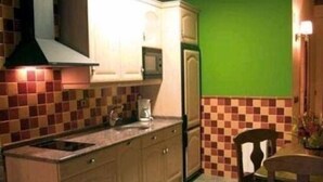 Une cuisine avec des meubles en bois, un four à micro-ondes et un mur vert.