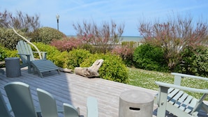 A wooden deck with Adirondack chairs, a concrete trash can, and a view of the ocean and trees. - House with terraces and unobstructed view of the beach with direct access (Saint-Aubin-Sur-Mer)
