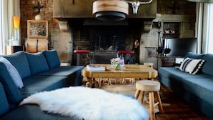 A cozy living room with a fireplace, two sofas, a coffee table, and a fluffy rug. - House with terraces and unobstructed view of the beach with direct access (Saint-Aubin-Sur-Mer)