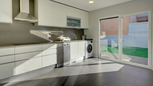 A modern kitchen with built-in appliances, a dishwasher, and a washing machine. - Summer Holiday family house  with swimming pool  (Fernão Ferro)