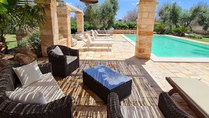 An outdoor patio with wicker furniture, a pool, and a bamboo ceiling. - Elegant villa with swimming pool in Salento  (Zona Centonze-Velodromo)