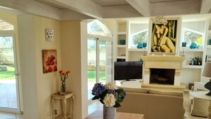 A spacious living room with a fireplace, a television, and a sofa. - Elegant villa with swimming pool in Salento  (Zona Centonze-Velodromo)