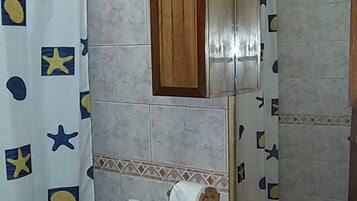A bathroom with a shower curtain featuring star patterns, a wooden cabinet, a mirror, a sink with a faucet, and a towel rack.