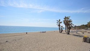 A beach with palm trees, a sandy shore, and a clear sky. - Casa Stefania - Marbellamar (Marbella)