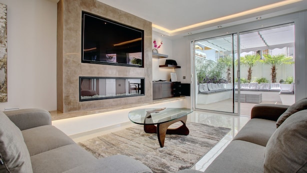 A modern living room with a flat-screen TV, a glass coffee table, and a sofa. - Casa Stefania - Marbellamar (Marbella)