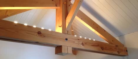 Una habitación con vigas de madera a la vista y techo inclinado.