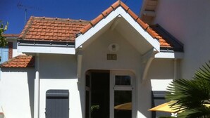 A building with a white facade, a red-tiled roof, and a small entrance with a door. - Charming Maisonette Pornic Gourmalon, near beaches, Thalasso, Shops (Pornic)