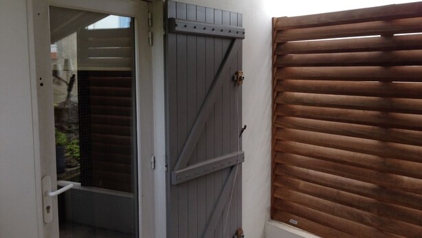 A door with a sliding barn door and a window with horizontal blinds. - Charming Maisonette Pornic Gourmalon, near beaches, Thalasso, Shops (Pornic)