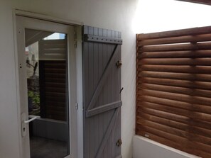 A door with a sliding barn door and a window with horizontal blinds.