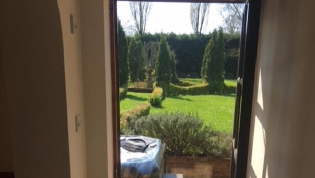 Una puerta que da a un patio con una parrilla y una pequeña mesa.