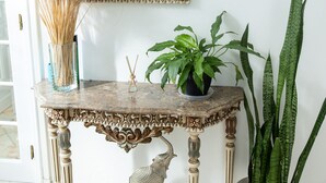 A decorative console table with a mirror, a vase with pampas grass, and potted plants. - TMO Residence 2 P. D.L (Ponta Delgada)