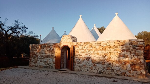 A stone building with a wooden door and a stone wall. - "Trulli Monte Madre 2" with Private Swimming Pool (San Vito dei Normanni)