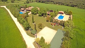 A large estate with multiple buildings, a swimming pool, and a tennis court.