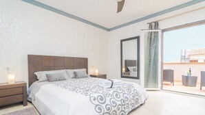 A bedroom with a large bed, a nightstand, a mirror, and a sliding glass door leading to an outdoor area with furniture. - LLUNA HOME - Chalet with terrace in Colonia de Sant Jordi. Free WiFi (Ses Salines)