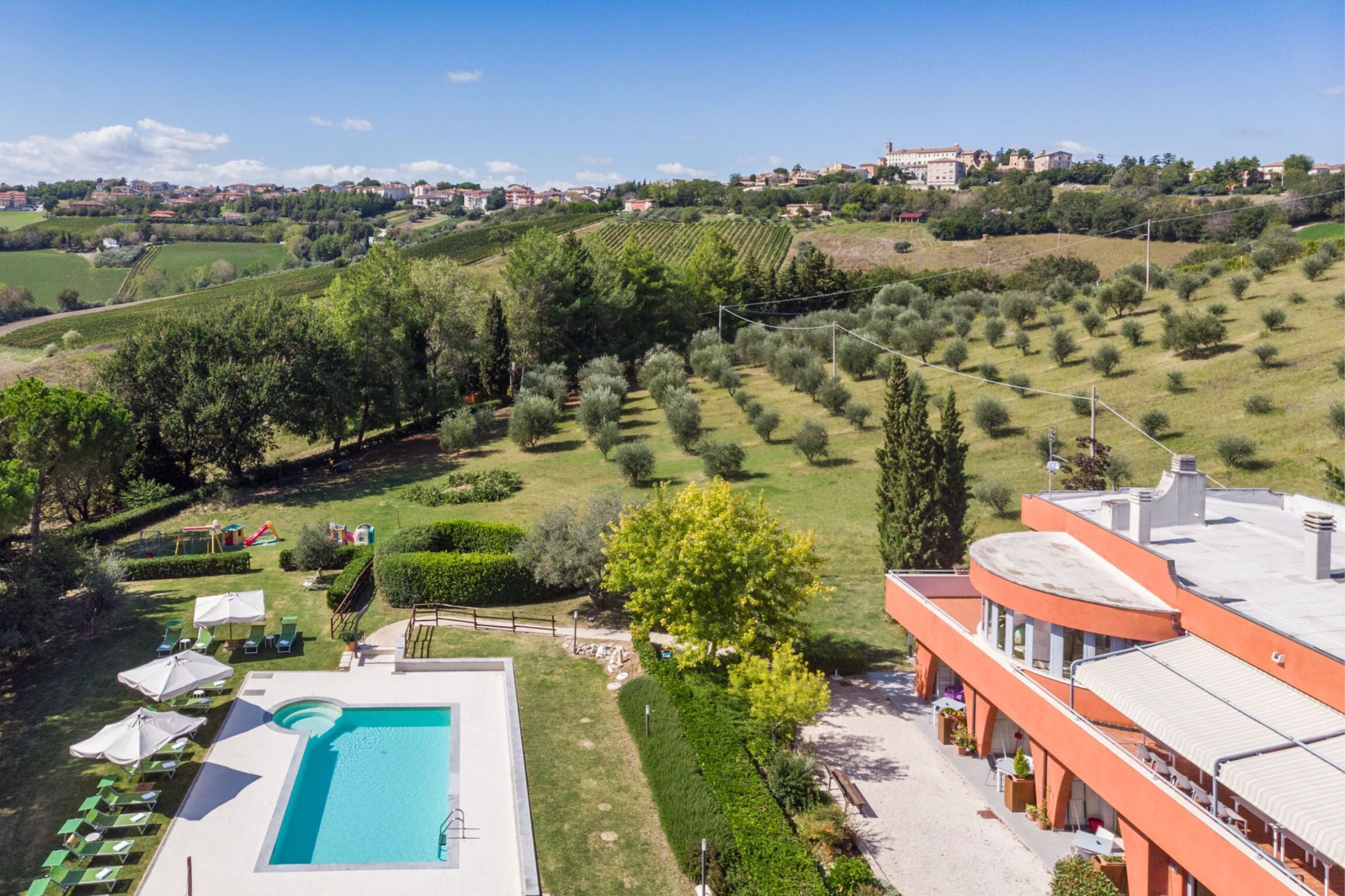 Un hotel con piscina, area relax all'aperto e vista sui vigneti e le colline.
