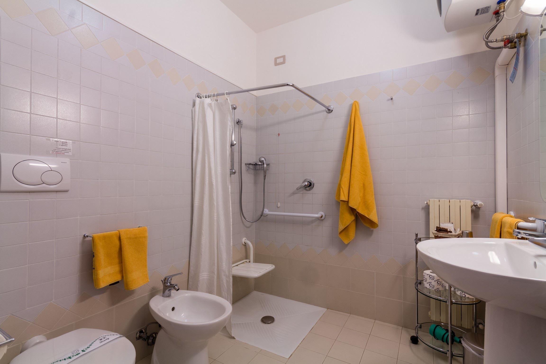 Une salle de bain équipée d’une douche, de toilettes, d’un lavabo et d’un porte-serviettes.