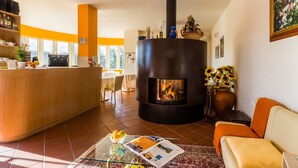 A cozy living area with a central fireplace, a wooden bar, and a sofa.