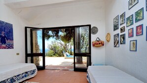 Ein Zimmer mit zwei Betten, einem großen Fenster und einer Wand mit gerahmten Fotos.