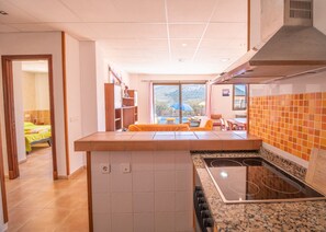A modern kitchen with a large island, a built-in oven, and a view to the outside.