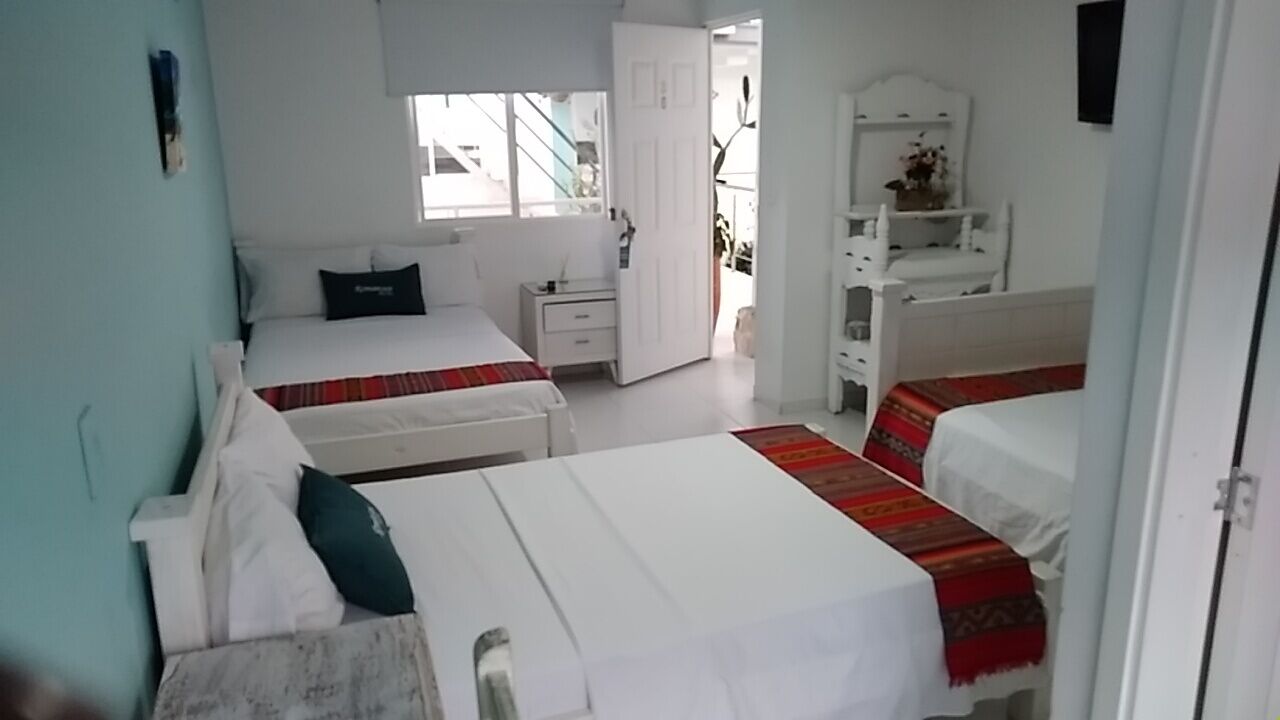 Ein Hotelzimmer mit zwei Betten, einem kleinen Schreibtisch und einem Kleiderschrank.