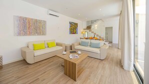 A modern living room with two sofas, a coffee table, and artwork on the walls. - Villa Jade II (Can Picafort)