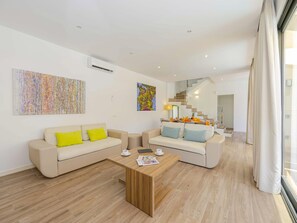 A modern living room with two sofas, a coffee table, and artwork on the walls.