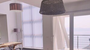 En moderne stue med sofa, sofabord i træ og en hængende lampe.
