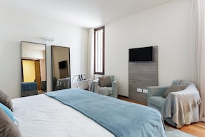 A hotel room with a bed, two armchairs, a TV, and a window. - Ca' Moro - Salina (Venice)