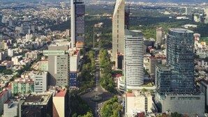 A cityscape with modern high-rise buildings, a central roundabout, and a mix of commercial and residential structures. - Very spacious and comfortable house (Arcos de Tlaxpana)