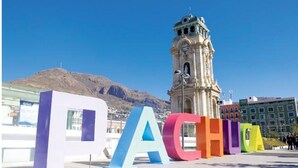 A clock tower with a clear view of the surrounding area, including a building with large colorful letters spelling "PACHU". - Very spacious and comfortable house (Arcos de Tlaxpana)