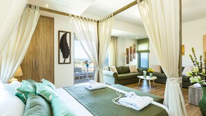 A spacious bedroom with a large bed, a sitting area with a sofa and chairs, and a balcony with a view. - Premium Beachfront Villa With Private Pool & Panoramic Sea Views From Any Angle (Rethymno)