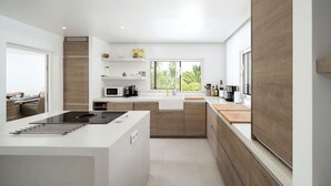 A modern kitchen with a central island, built-in appliances, and a view of greenery outside. - Fabulous spacious villa [57] (Lagos)