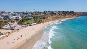 A coastal town with a sandy beach, clear blue sea, and residential buildings along the cliff. - Fabulous spacious villa [57] (Lagos)