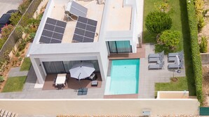 A modern house with a swimming pool, solar panels, and a tennis court. - Modern accessible villa [17] (Luz)