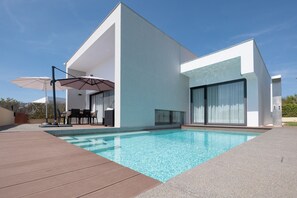 A modern house with a swimming pool, outdoor furniture, and a patio area. - Modern accessible villa [17] (Luz)