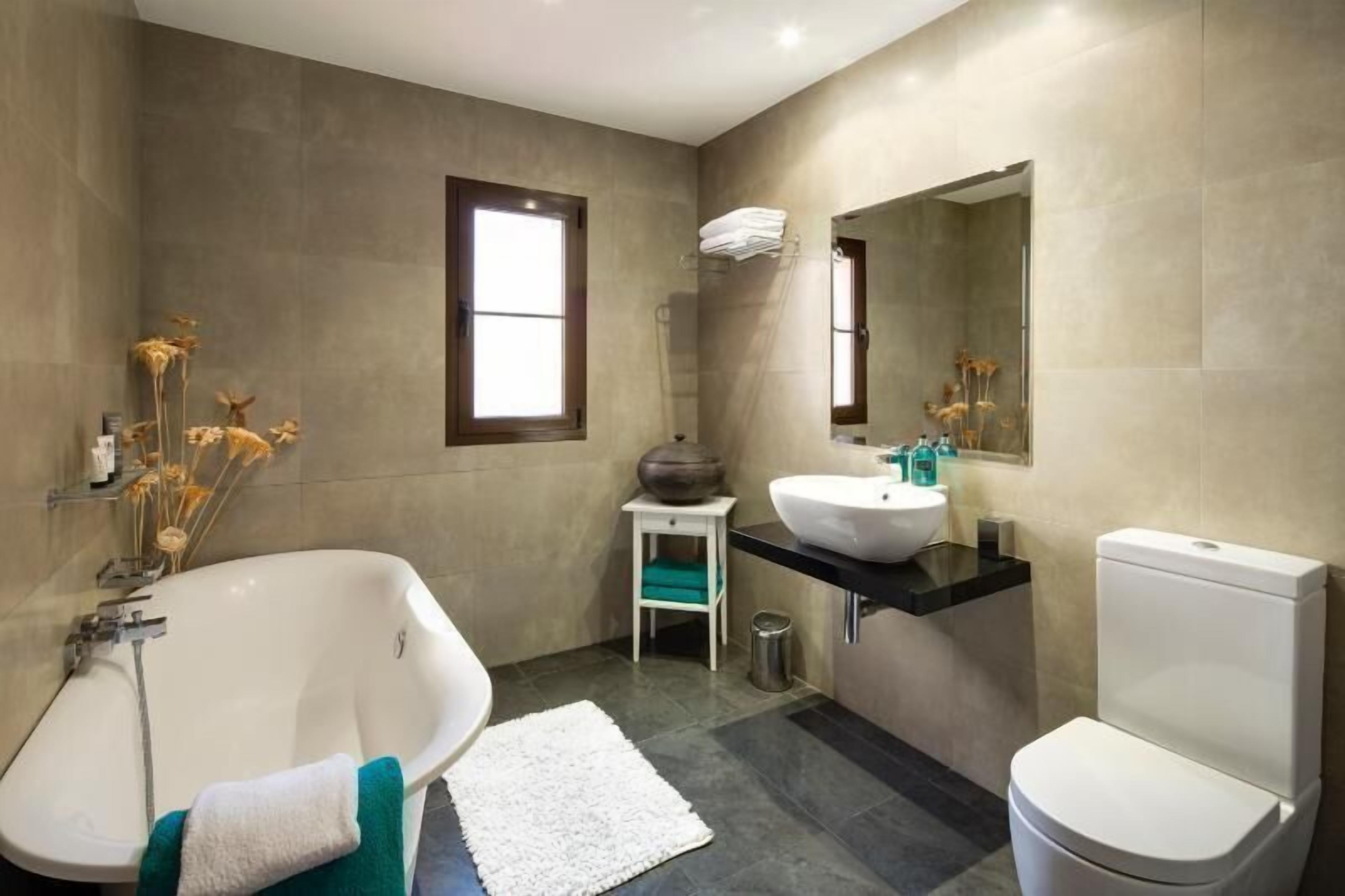 Une salle de bain moderne avec une baignoire sur pieds, un lavabo et des toilettes.