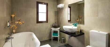 Une salle de bain moderne avec une baignoire sur pieds, un lavabo et des toilettes.