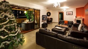 A modern living room with a large Christmas tree, leather sofas, a fireplace, and a dining area. - Luxury Villa near to Mijas Pueblo that sleeps 14. With Large Private Heated Pool (Mijas)