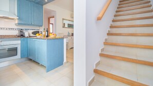 A modern kitchen with blue cabinets, a central island, and a wooden staircase. - MARINA D'OR IV CASA 5 - Chalet with shared pool in Cala D'Or. Free WiFi (Santanyí)