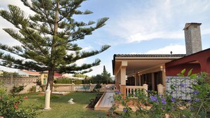A house with a covered patio, a swimming pool, and a large tree in the yard. - Beautiful villa with private pool excelent for families. Aircond and wifi available - Free Wifi (Llucmajor)