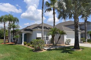 Situated on a quiet street, this single-story house features a gabled roof and a welcoming front porch.