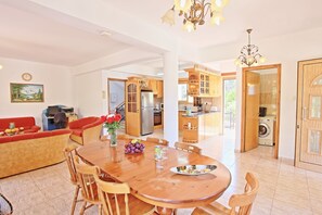 Cozy living area with a dining table, sofa, and kitchen in the background.