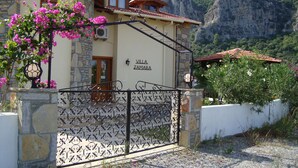 Una villa con fachada de piedra, una puerta de madera y un cartel que dice "Villa Jamara".