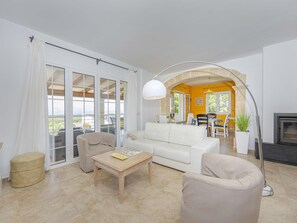 A living room with a sofa, chairs, a coffee table, and a fireplace. - Villa Heura· Villa with private pool in Alcúdia (Alcúdia)