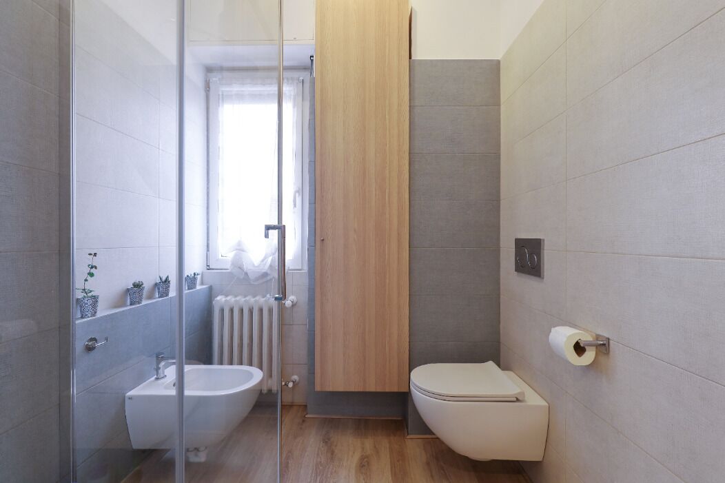 Un bagno moderno con box doccia in vetro, un water e un bidet.