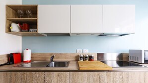 Una cocina moderna con armarios de madera, un lavamanos de acero inoxidable, un microondas y una encimera de madera.