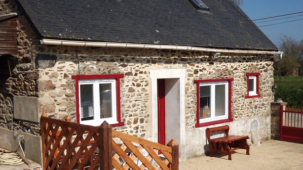 A stone house with a red door and windows, a wooden gate, and a bench outside. - Breton house 2 bedrooms bathroom / living room / kitchen (Ploezal)